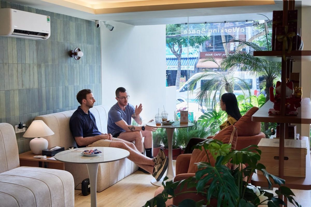 Travellers talking in a bright co-working café in Da Nang